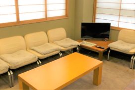 イスとテーブルとテレビがある待合室