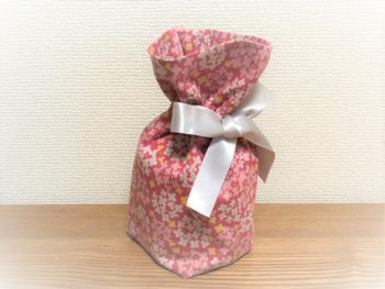 ピンク生地に花柄の骨入れ袋。