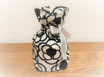 白地に黒の花柄の骨入れ袋。