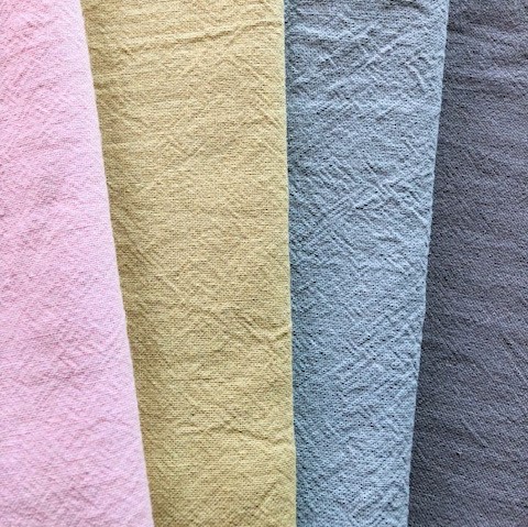 麻と綿の混合生地が4色並んでいる様子。