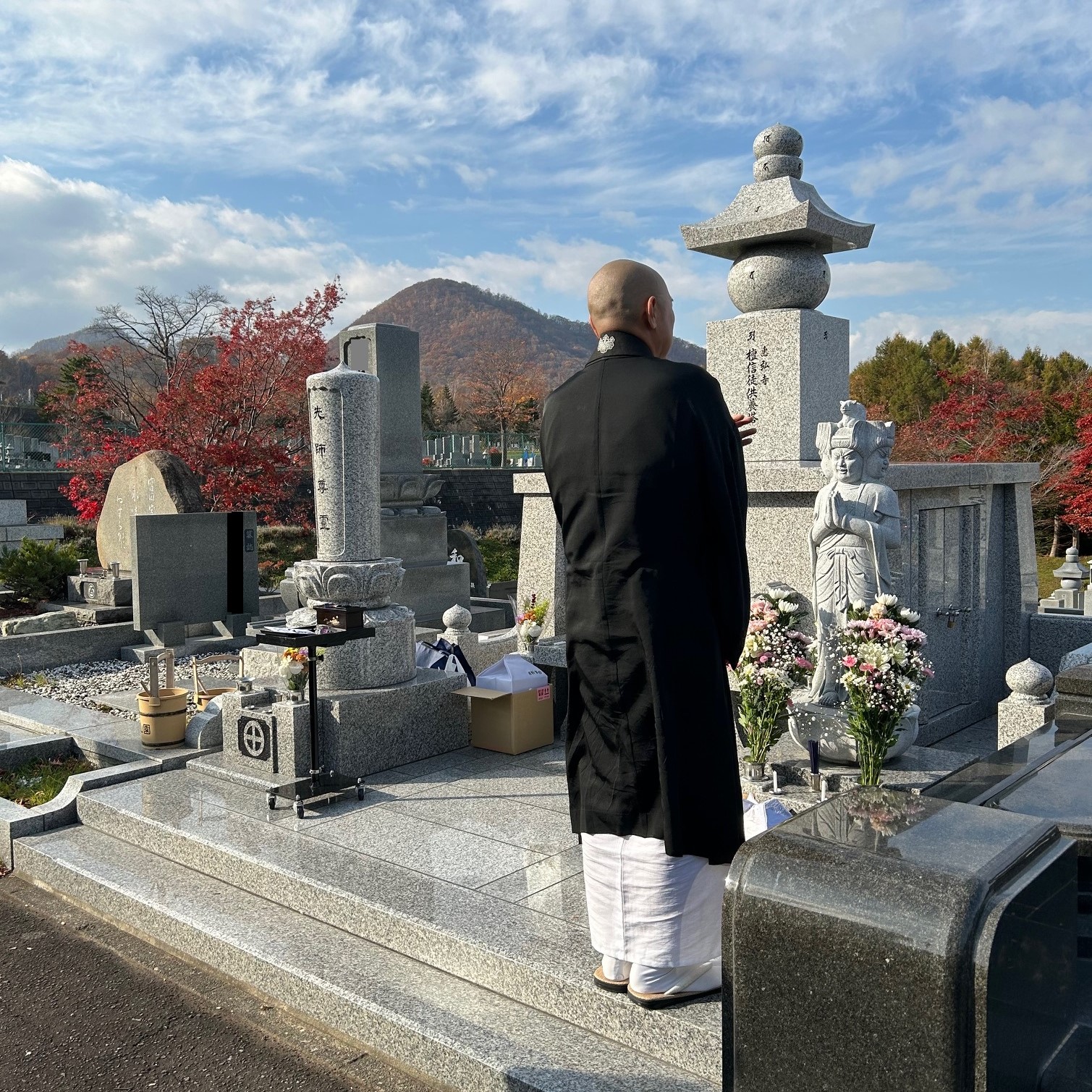 ペット達の墓と読経供養の祈りを捧げている仏教僧侶。