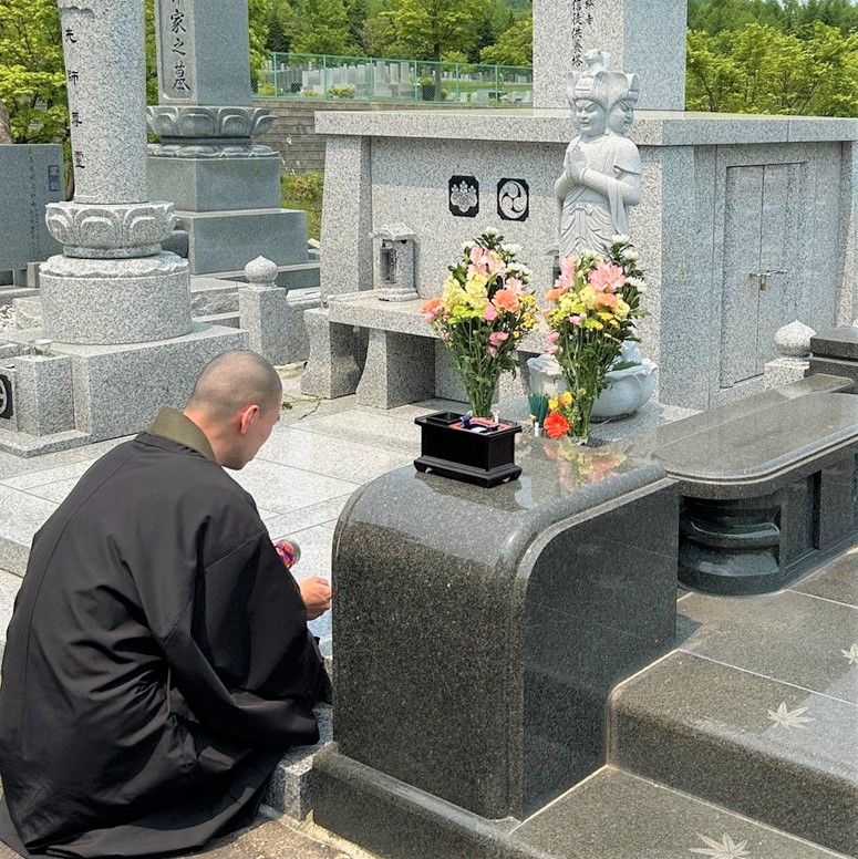 ペット達の墓と読経供養の祈りを捧げている仏教僧侶。