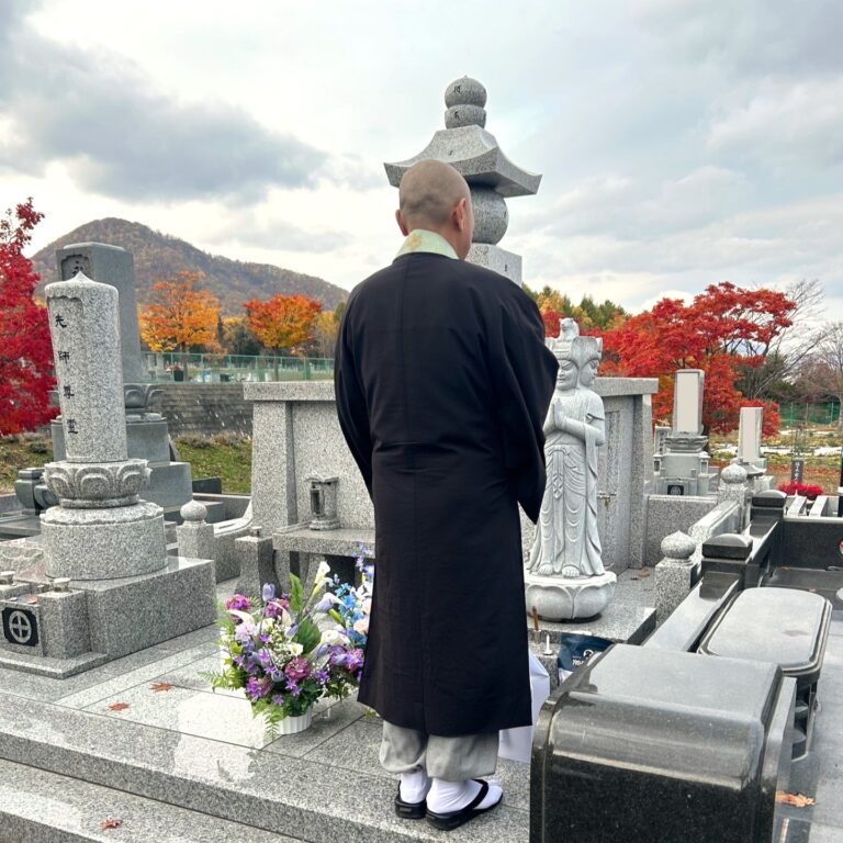 ペット達の墓と読経供養の祈りを捧げている仏教僧侶。